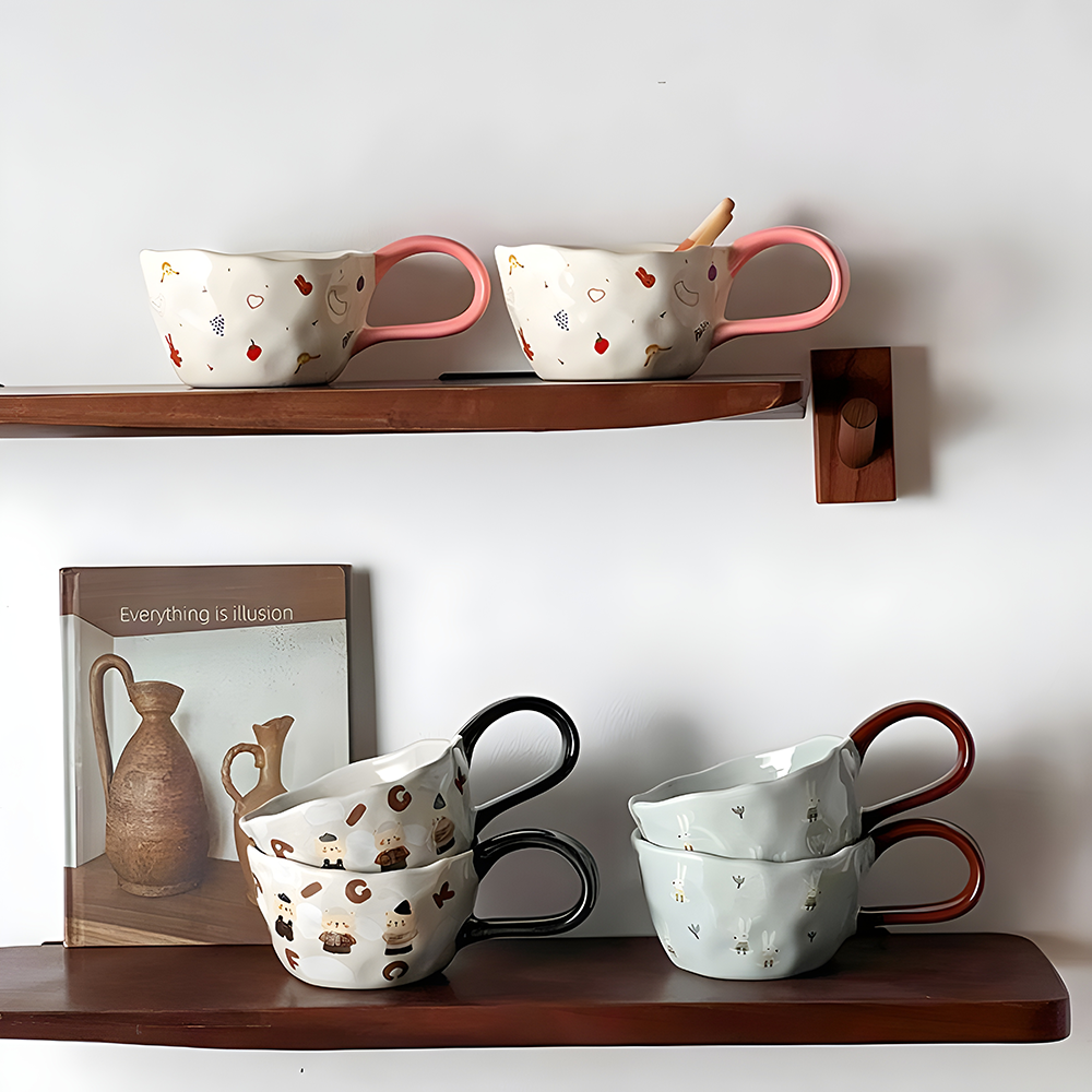 2 cream based ceramic mugs with little girl, red cherry, heart, strawberry, bunny and grape print, a big loop pink handle on the top shelf, on the bottom shelf, 2 of each bear patterned and bunny patterned big loop mug stacking