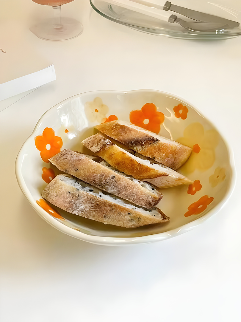 a orange yellow flower patterned with cream base ceramic bowl filled with sliced bread